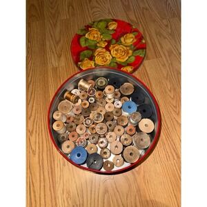 Vintage tin full of wooden sewing spools